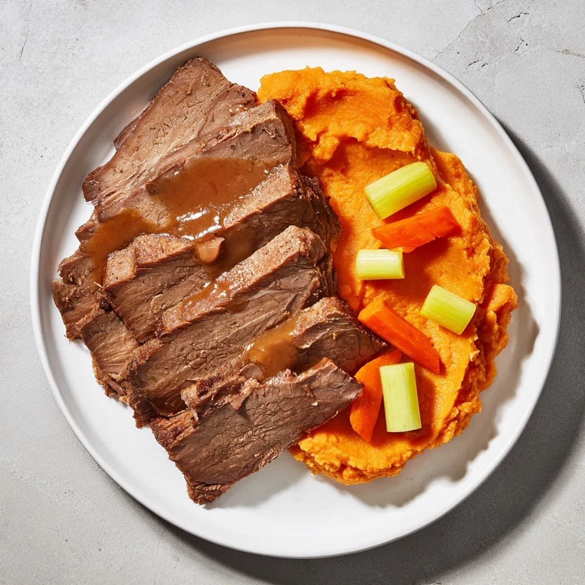 A close-up shows juicy, slow-cooked Classic Brisket & Mashed Sweet Potatoes, ready to be enjoyed.
