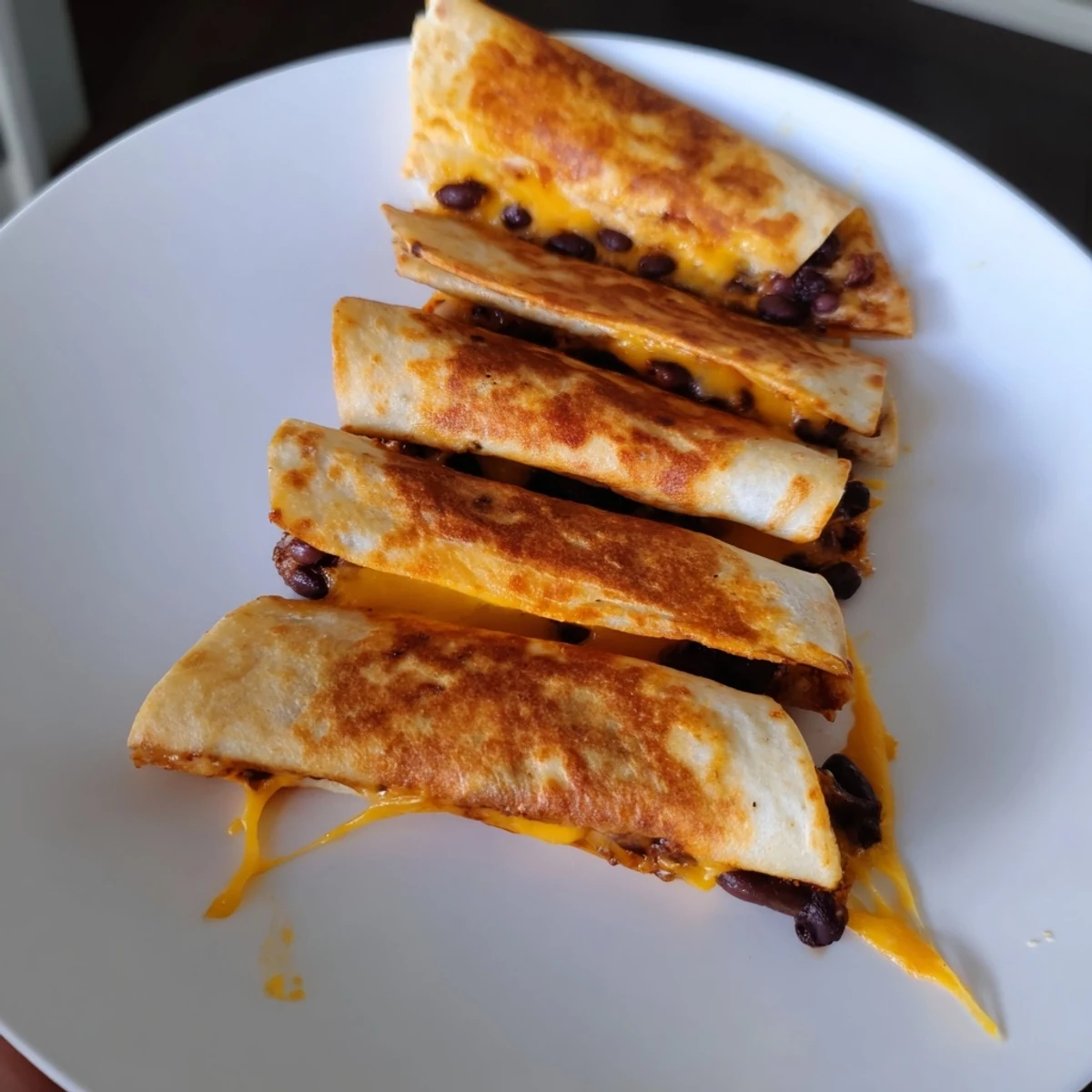 Crispy, golden-brown tortilla halves filled with savory beans and cheese: the easy Bean & Cheese Quesadilla.