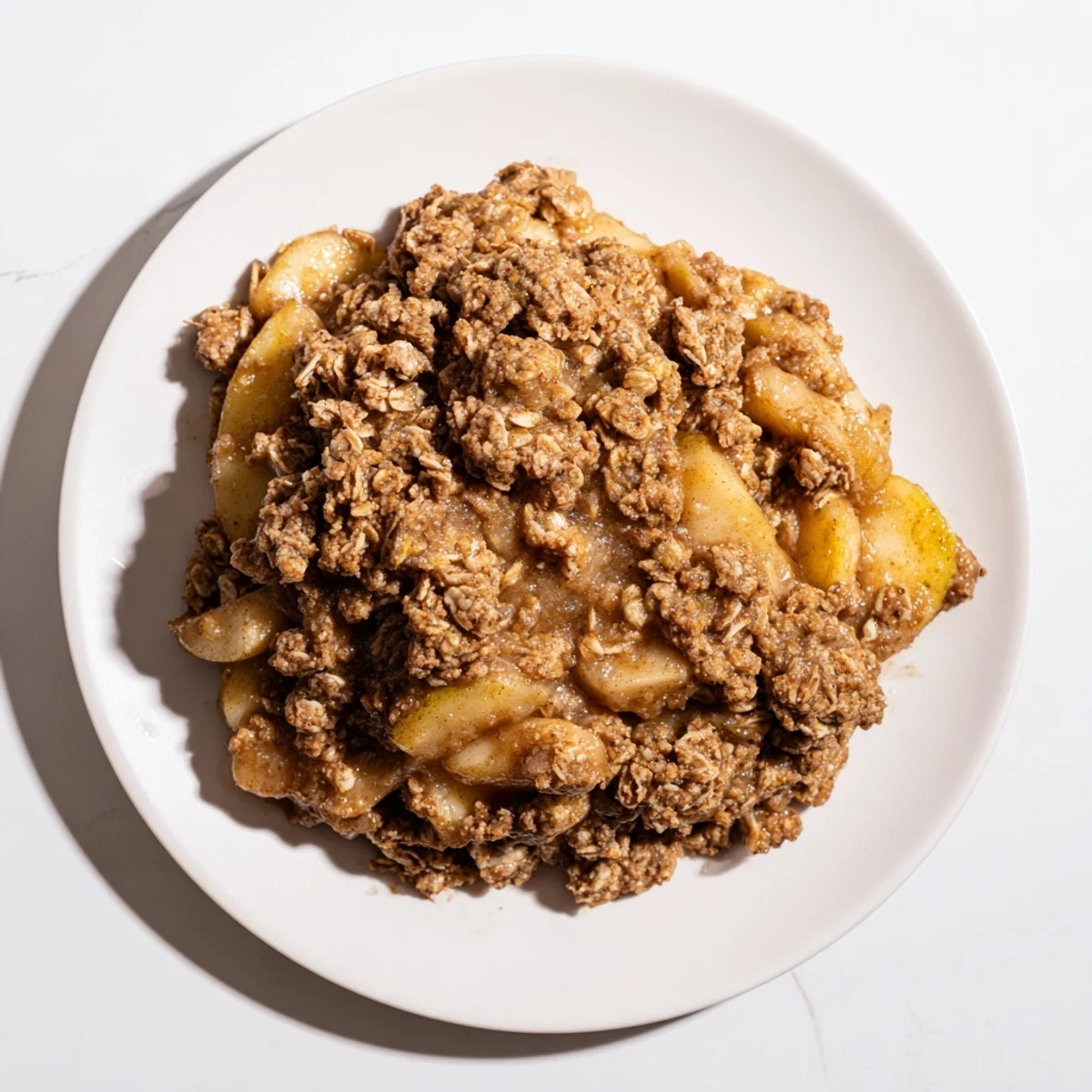 Golden brown apple crisp with warm, bubbly fruit filling, a delicious dessert served with vanilla ice cream.