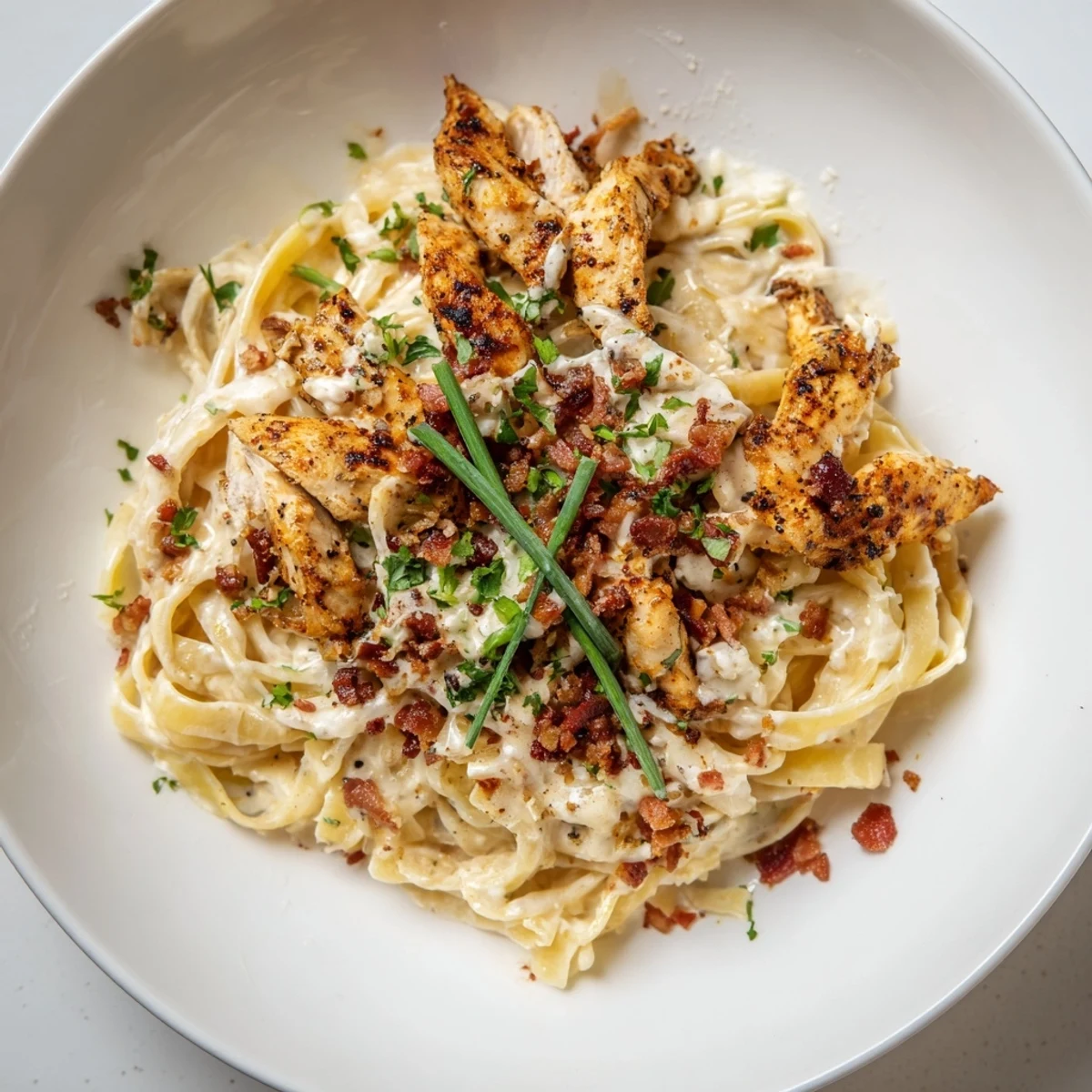 Perfectly cooked Southern Style Creamy Parmesan Chicken Pasta is enhanced with fresh herbs and crumbled bacon on top.