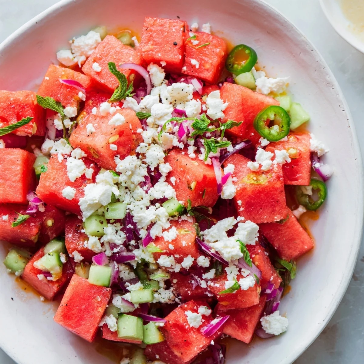 A bright, colorful photo showcases the chilled Cucumber and Watermelon Hot Girl Salad with crumbled feta.