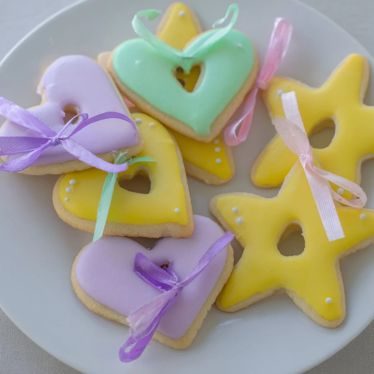 Delicate Mignonneries Coeurs et Étoiles Rubans cookies, iced and tied with festive ribbons, a perfect gift.