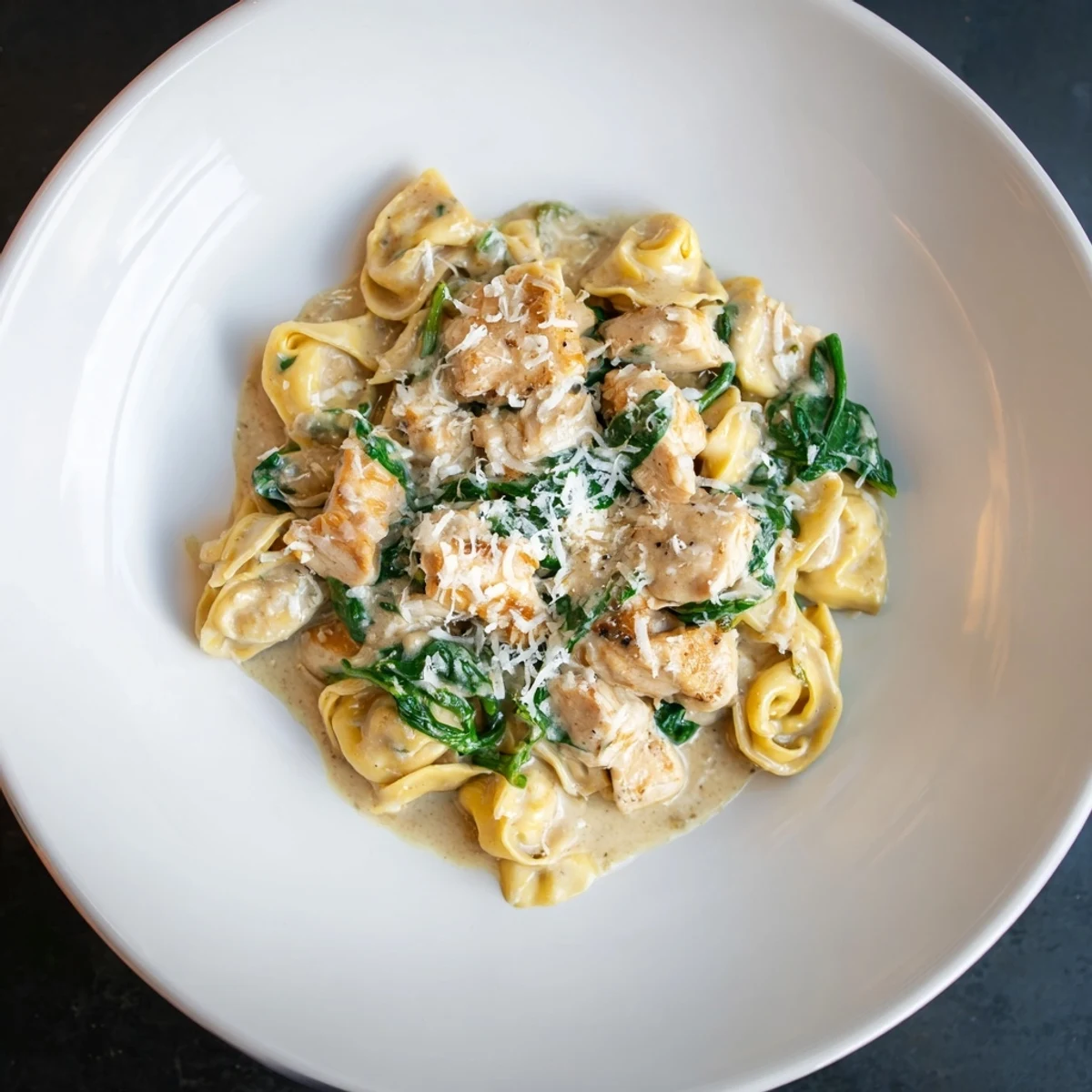 Enjoy a comforting bowl of Italian-American Creamy Chicken and Spinach Tortellini, perfect for dinner.