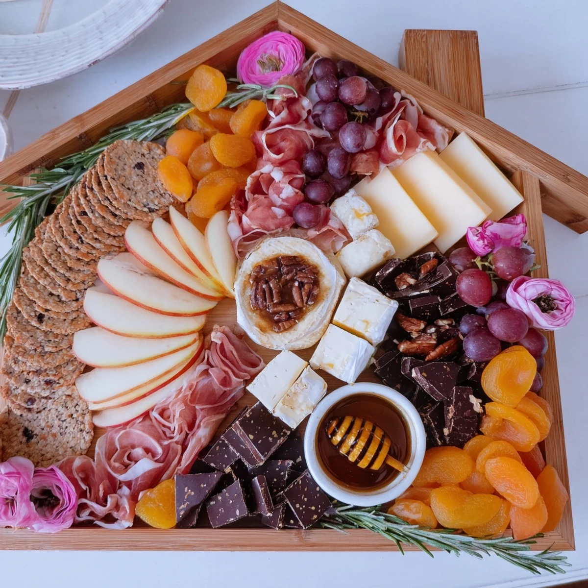 House-shaped Sweet Home Charcuterie Board showcases an array of sweet and savory snacks and treats.