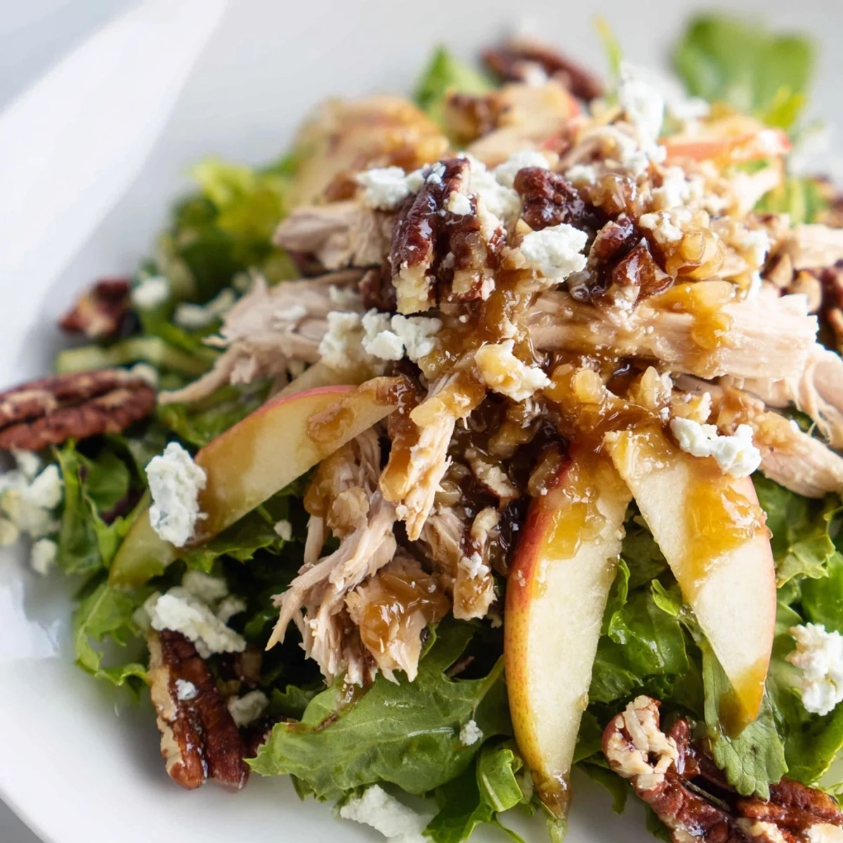 Fresh slices of Honeycrisp apple top tender chicken breast and crumbled feta on a bed of mixed greens, finished with a drizzle of caramel-pecan dressing.