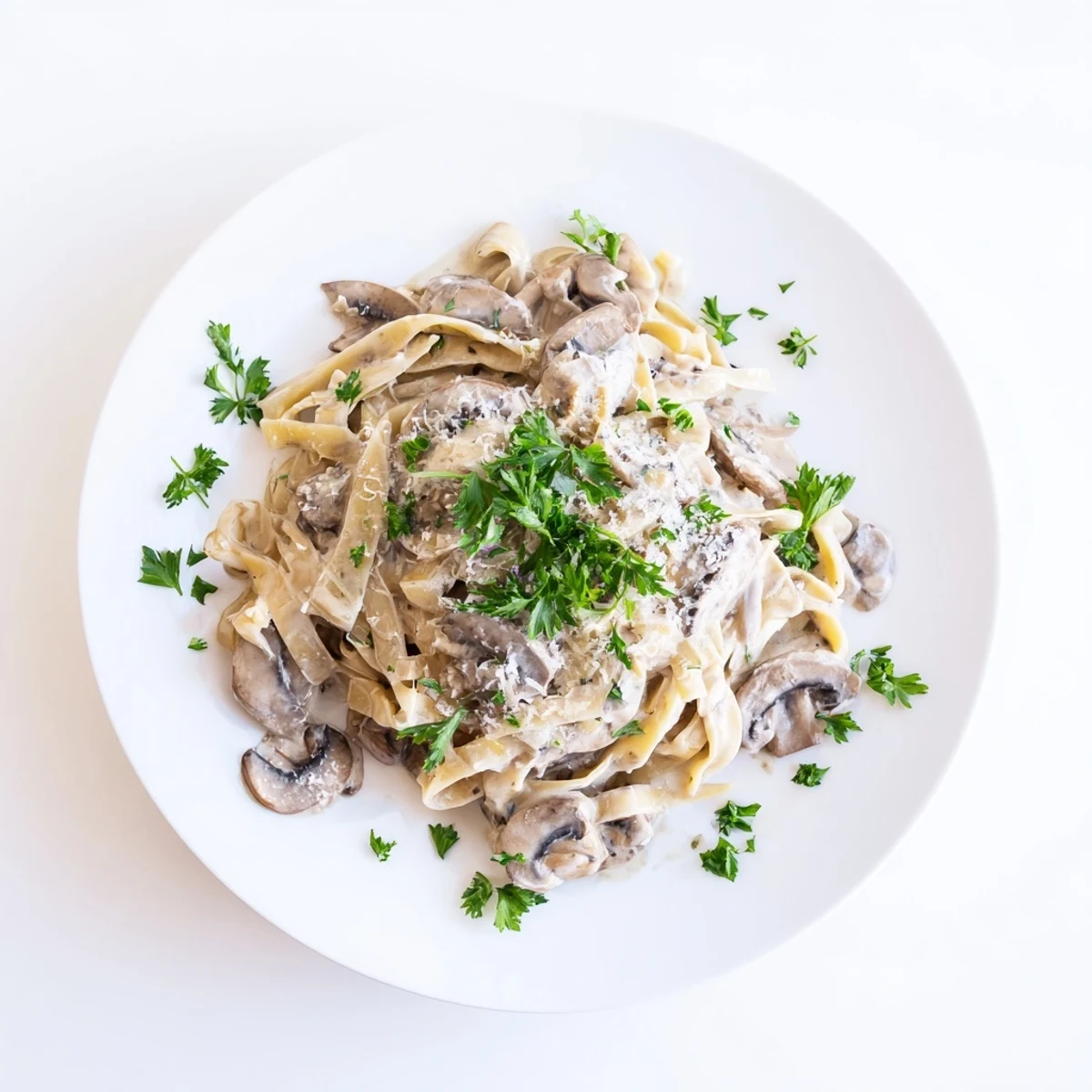A skillet of Creamy Mushroom Alfredo shows sautéed golden mushrooms tossed in a luscious garlic parmesan cream sauce with fettuccine noodles.