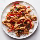 Steaming jasmine rice topped with savory Thai Basil Chicken Bowls, garnished with fresh basil leaves.