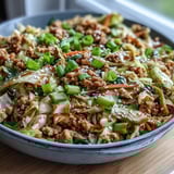 Freshly cooked Keto Egg Roll in a Bowl with ground turkey served in a white bowl, topped with toasted sesame seeds and extra scallions.