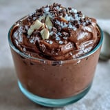 Four chilled Vegan Chocolate Avocado Mousse Cups garnished with almond crunch and salt, ready to serve for dessert.