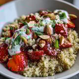 A vibrant bowl of Strawberry Basil Breakfast Quinoa with creamy plant-based yogurt and crunchy almonds for a nutritious morning meal.