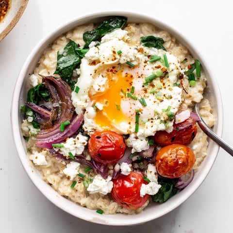 Savory oatmeal bowl: Creamy, comforting breakfast topped with vibrant sautéed vegetables and a fried egg.