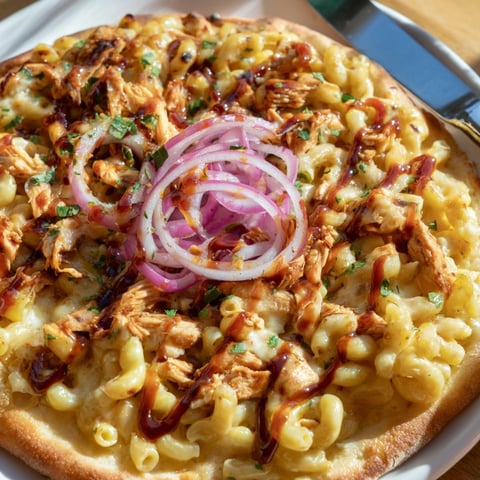 Close-up of golden Mac and Cheese BBQ Chicken Pizza, bubbly cheese and crispy crust.