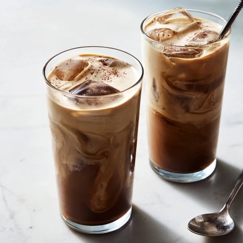 Refreshing Tahini Iced Coffee topped with creamy plant-based milk and ice.  