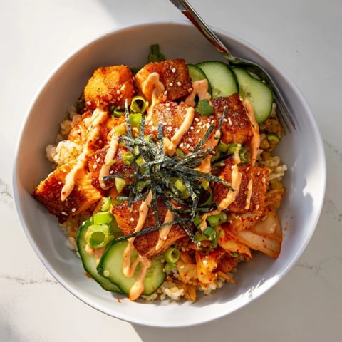 Crispy Salmon Rice Bowl garnished with avocado, kimchi, and spicy mayo drizzle.  
