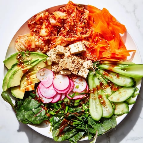 A colorful fermented vegetable bowl with kimchi and fresh greens for a tasty meal.