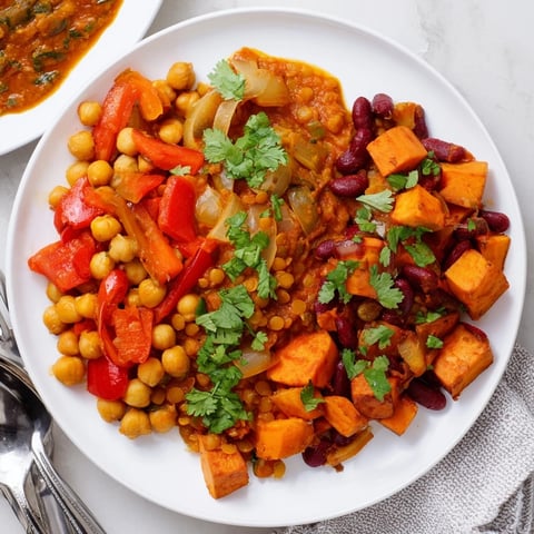 Vibrant Indian Chickpea Curry simmering in a skillet with fresh herbs and spices.  