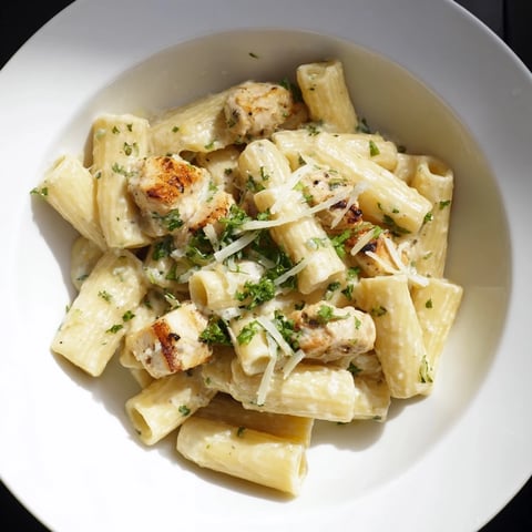 Creamy Garlic Parmesan Chicken Rigatoni, a comforting plate of pasta with rich, bubbly, white sauce.