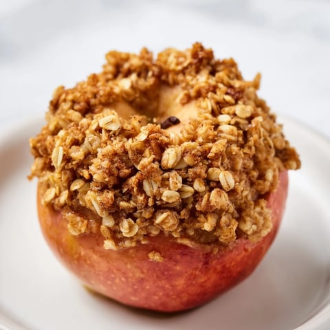 Golden, bubbly Baked Apples with Oat-Nut Crumble, served warm, perfect for a cozy fall dessert.