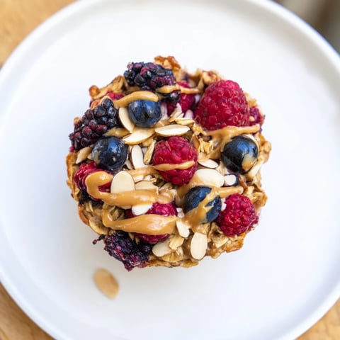 Golden-brown baked oatmeal cups studded with winter berries, a delicious and easy breakfast delight.