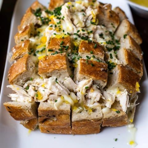 Warm, cheesy Leftover Chicken Bake Pull-Apart Bread, with golden brown cheese bubbling near the surface.