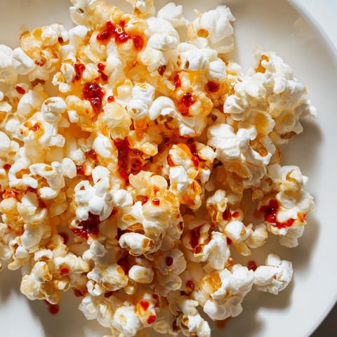 Golden-brown Hot Honey Butter Popcorn with a glistening coating, perfect for a cozy snack.