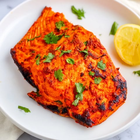 Golden-brown Indian Tikka Salmon, flaky and aromatic, ready to enjoy with a squeeze of lemon.