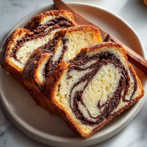 Warm chocolate cinnamon swirl bread loaf resting on a wire rack, ready to serve