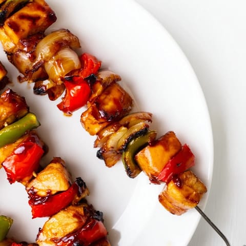 Colorful chicken skewers with bell peppers and onions drenched in teriyaki glaze.  