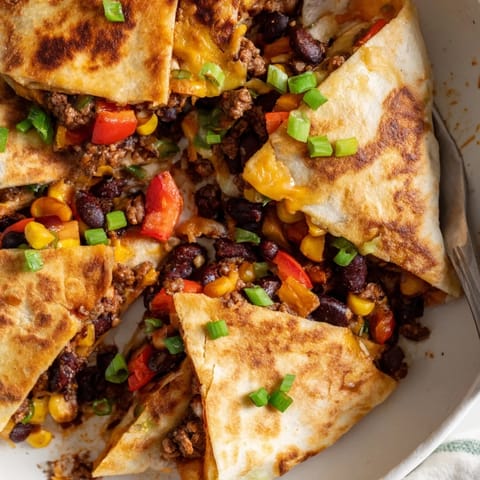 Golden Sheet Pan Quesadillas with Beef, melted cheese, and vibrant toppings on display.  