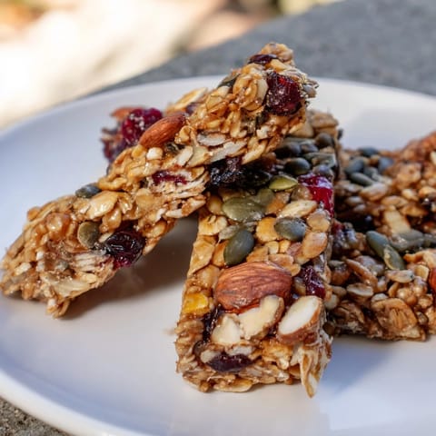 Close-up of freshly baked Roasted Pumpkin Seed & Cranberry Granola Bars, ready to be sliced into delicious snack bars.