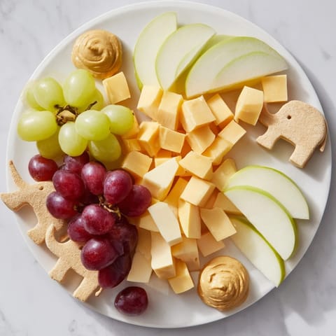 Vibrant image of a Gentle Giant Elephant Cracker Board, offering a variety of cheeses and fresh fruits for snacking.