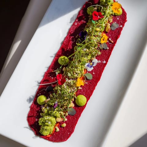 A striking shot of The Modernist Stripe with layers of colorful vegetable purées elegantly arranged for serving.