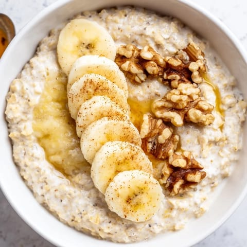 Close-up of creamy Microwave Banana Oats, beautifully garnished with fresh banana and nuts.