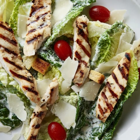 Tender sliced grilled chicken tops romaine salad in a light Greek yogurt Caesar dressing.