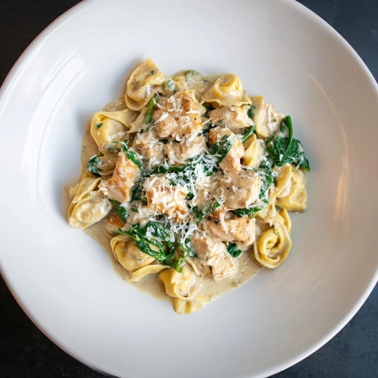 Enjoy a comforting bowl of Italian-American Creamy Chicken and Spinach Tortellini, perfect for dinner.