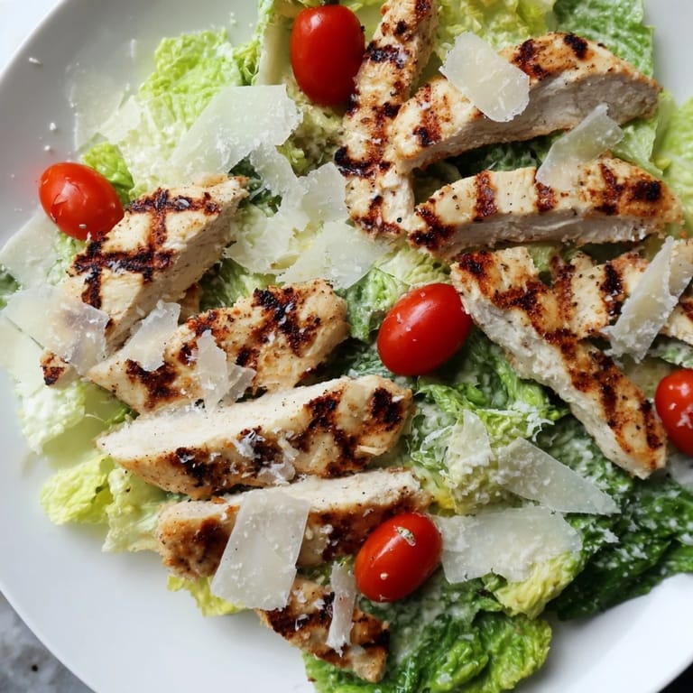 Hearty main dish salad features grilled chicken, romaine, croutons, and shaved Parmesan.